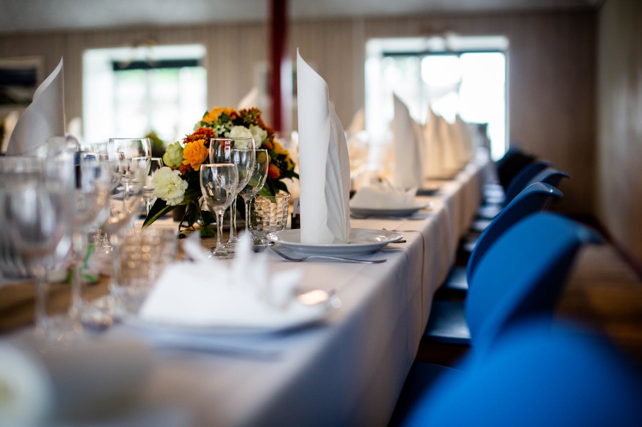 A beautifully arranged dining table with floral centerpieces and elegant tableware, ideal for a wedding reception.